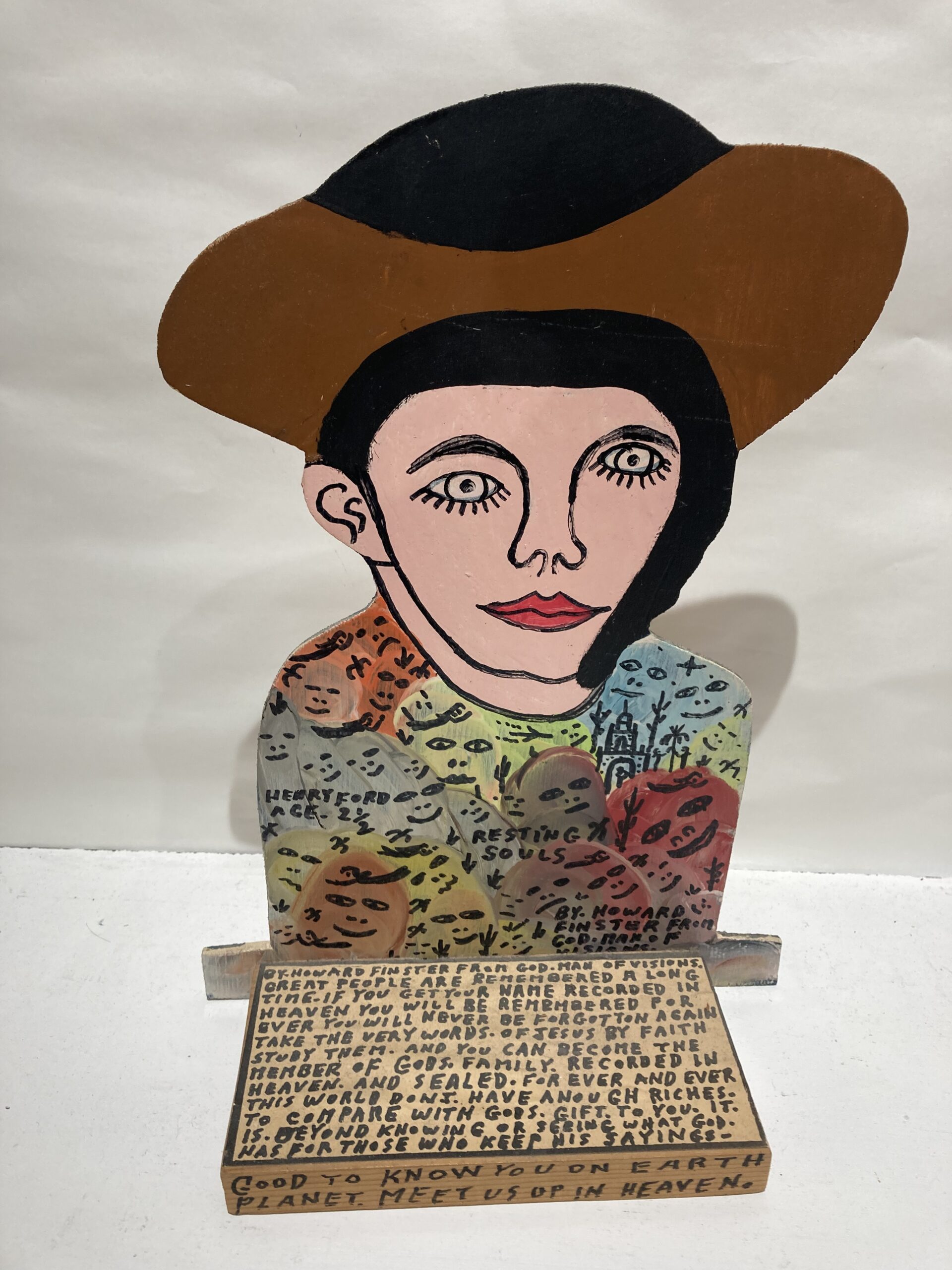 Œuvre de Howard Finster représentant un personnage au large chapeau accompagné d’inscriptions peintes